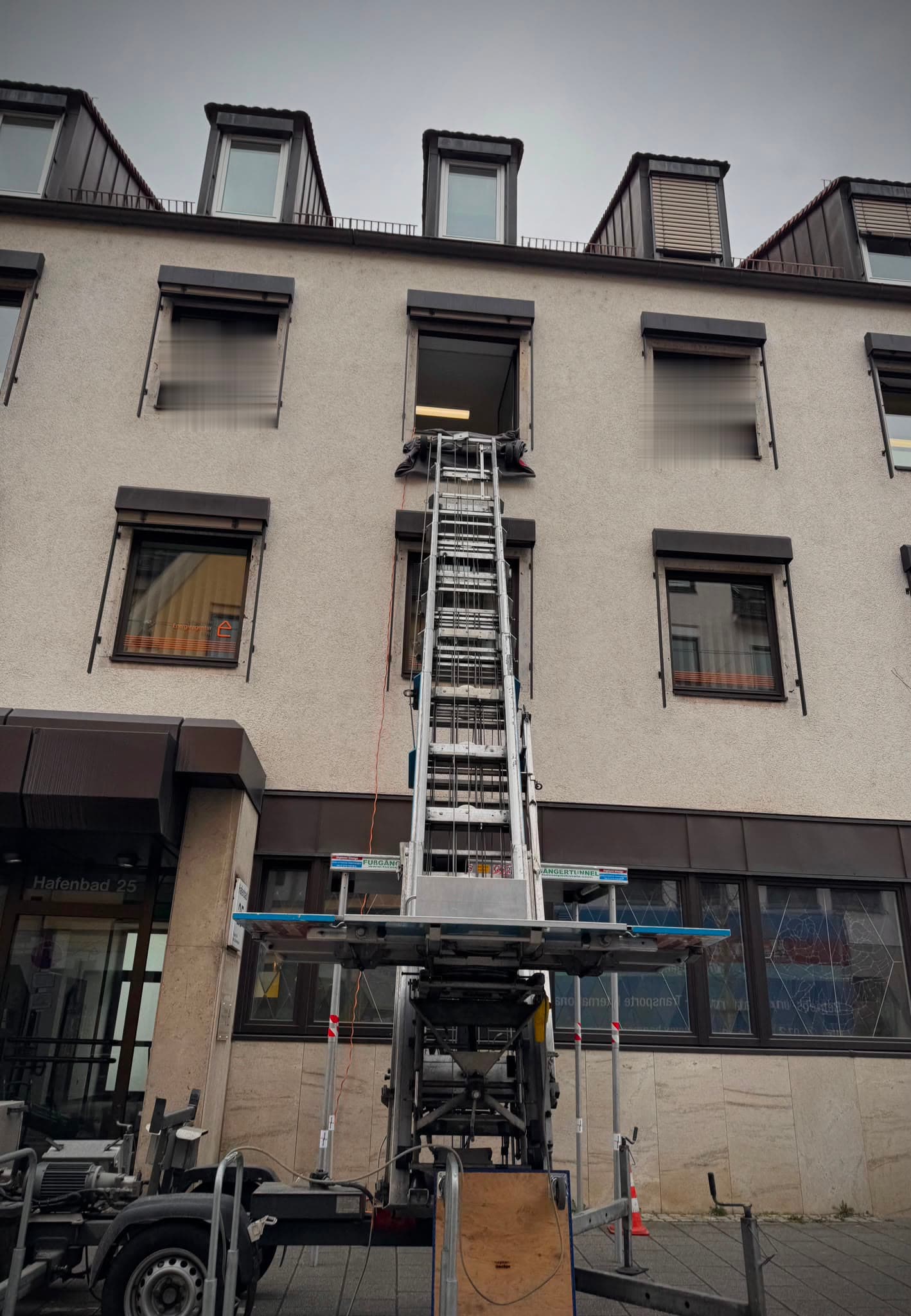 Möbellift an der Hausfassade, ausgefahren bis zum Fenster im zweiten Obergeschoss