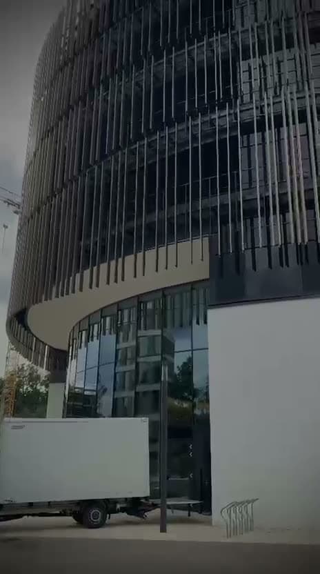 Umzugsfahrzeug von Leos Umzugslogistik vor einem modernen Bürogebäude