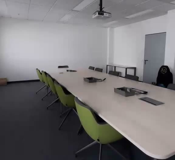 Fertig aufgebauter Konferenzraum mit langem Besprechungstisch nach einem Büroumzug