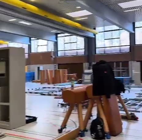 Geräumte Schulsporthalle mit Transportboxen und demontierten Sportgeräten